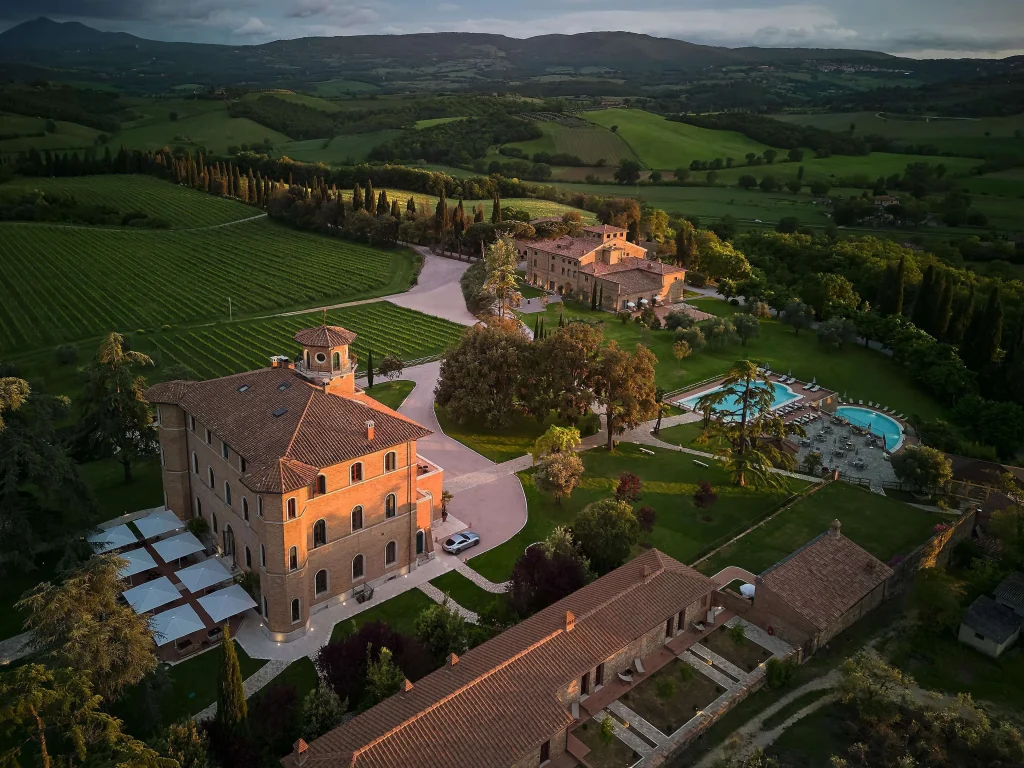 Traditional Tuscan estate with warm earth-toned facades, terracotta roofs, and architecture inspired by the surrounding landscape.