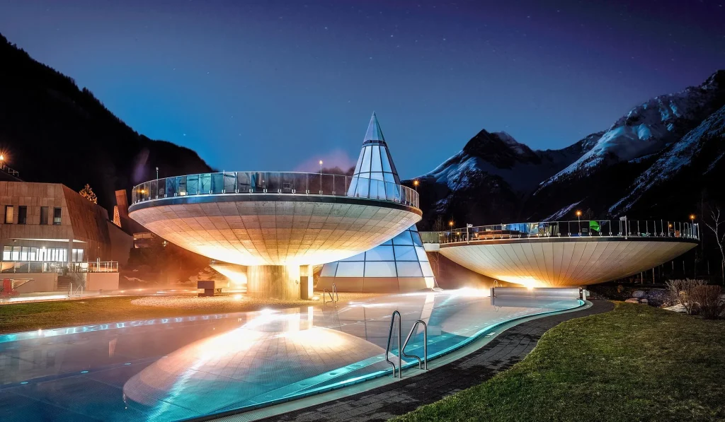 Futuristic disc-shaped spa structure of Aqua Dome rising above the Tyrolean Alps