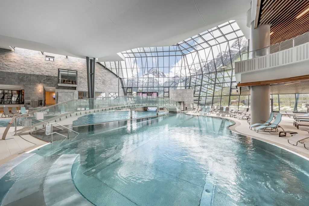 Indoor thermal bathing hall at Aqua Dome Austria with floor-to-ceiling mountain views