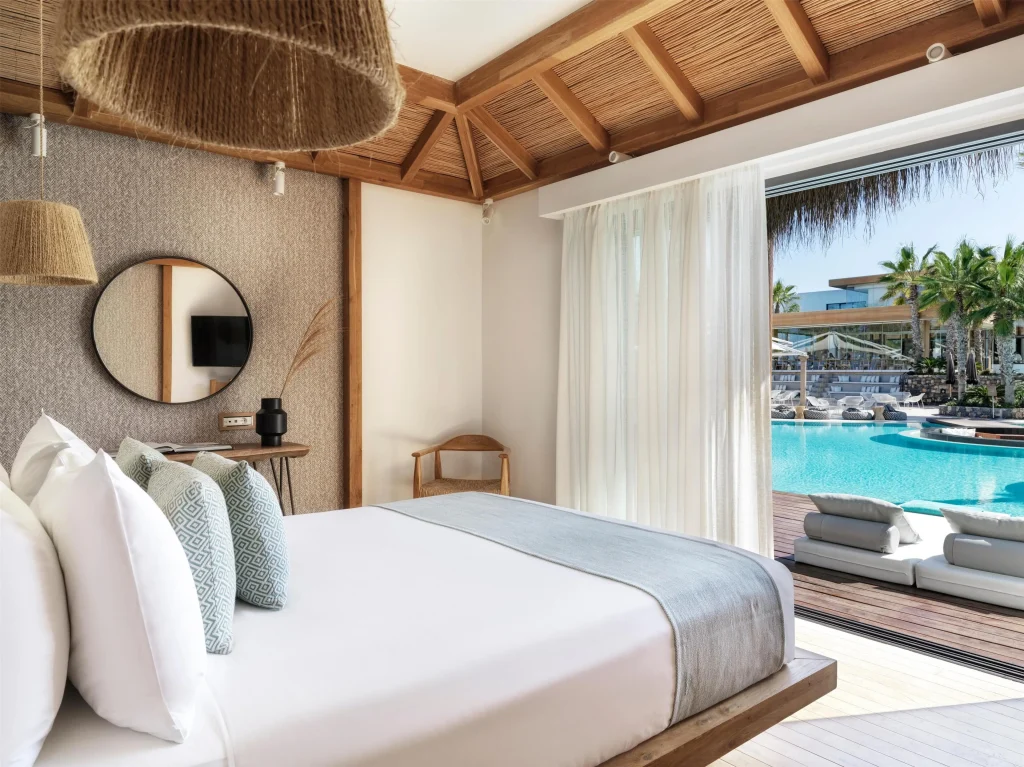Stella Island Crete overwater bungalow interior large windows lagoon view
