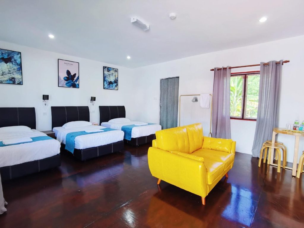 Interior of Mushrooms Inn mushroom house — single beds, yellow sofa, and curved interior walls