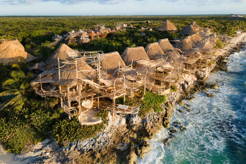 Azulik Tulum aerial view showing 48 organic wooden villas woven into the Mayan jungle canopy above the Caribbean coast