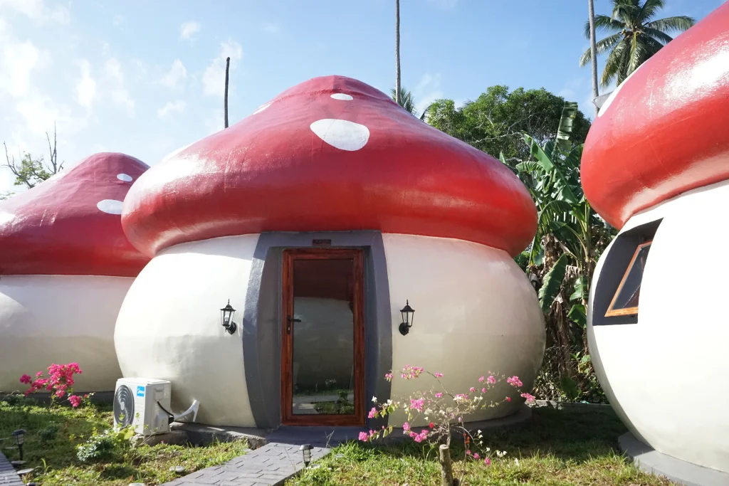 Garden view at Mushrooms Inn, Semporna — mushroom-shaped cottages among tropical greenery in Sabah, Malaysia