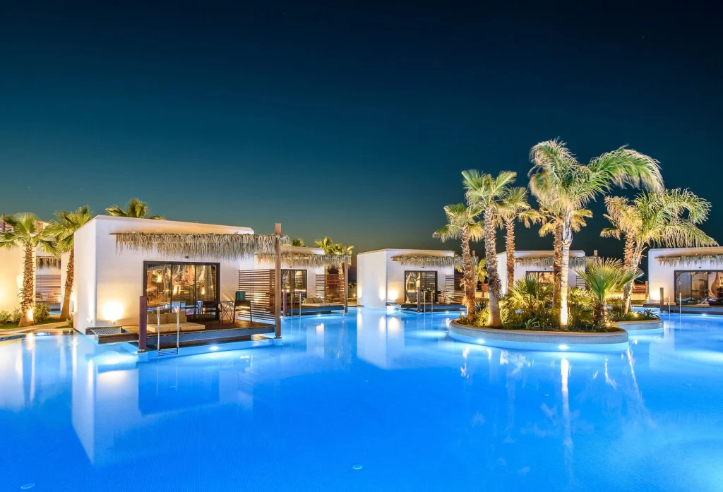 Stella Island Crete evening golden hour lagoon reflection floating resort architecture