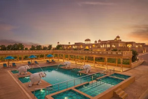 Pool and landscaped grounds surrounded by palace-inspired architecture in Jaisalmer